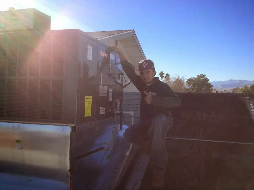 HVAC technician performing AC Tune-Up on a rooftop unit in Eastman